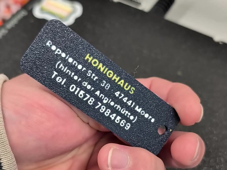 Rückseite des Schlüsselanhängers mit Adresse des Honighauses in Moers und Telefonnummer